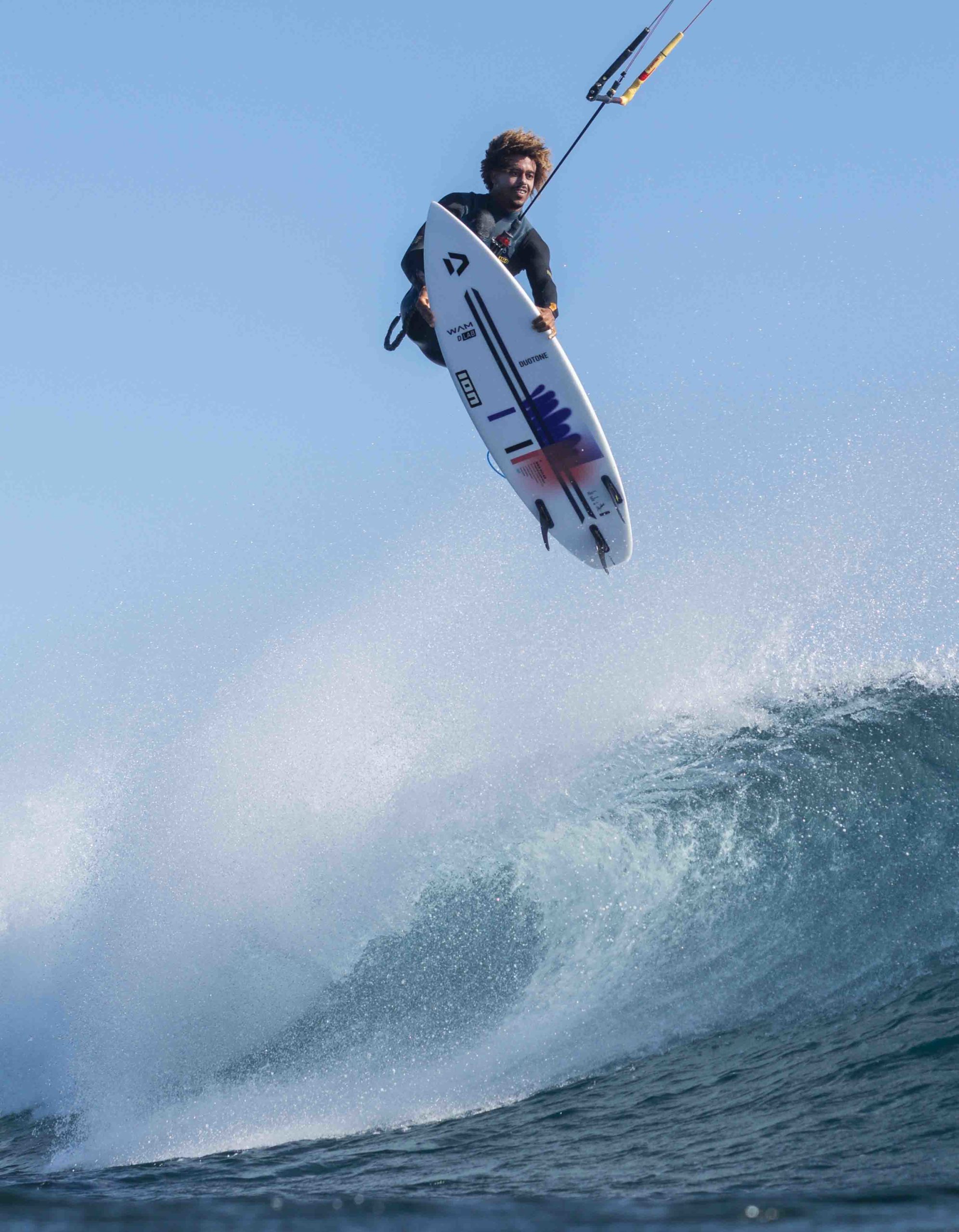 kitesurfer jumping above a wave